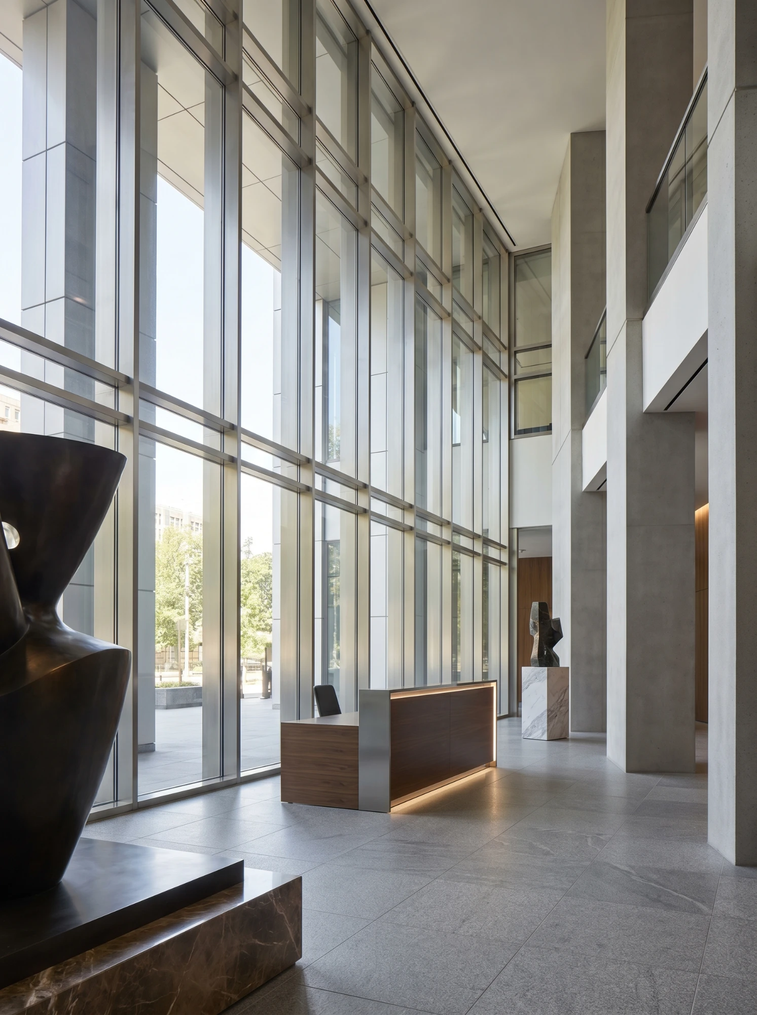 Modern corporate glass lobby with reception desk and sculptural art — extraordinary ability