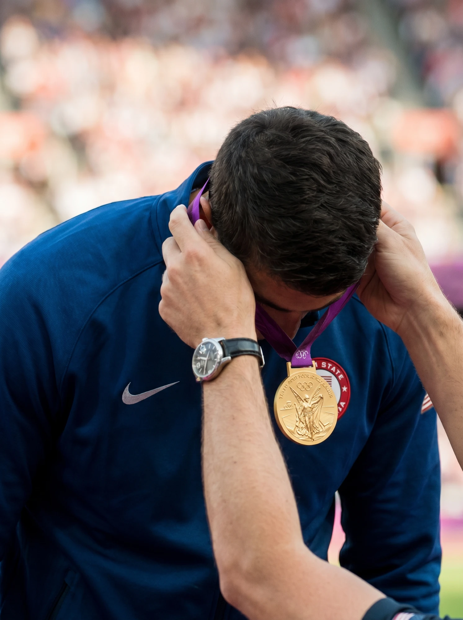 Olympic gold medalist bowing to receive the gold medal at the ceremony — extraordinary ability