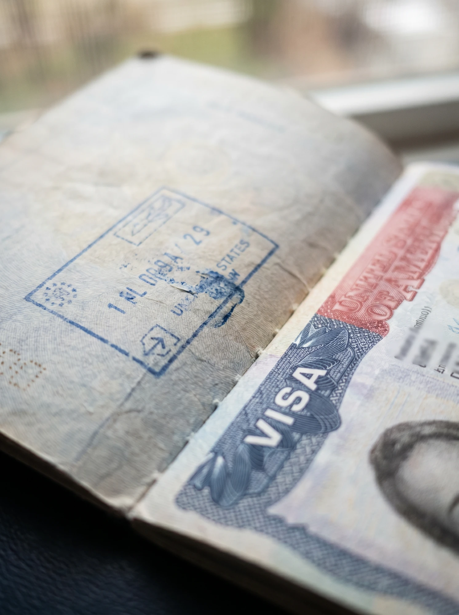 Macro close-up of US visa stamp and passport pages — intracompany transferee documentation